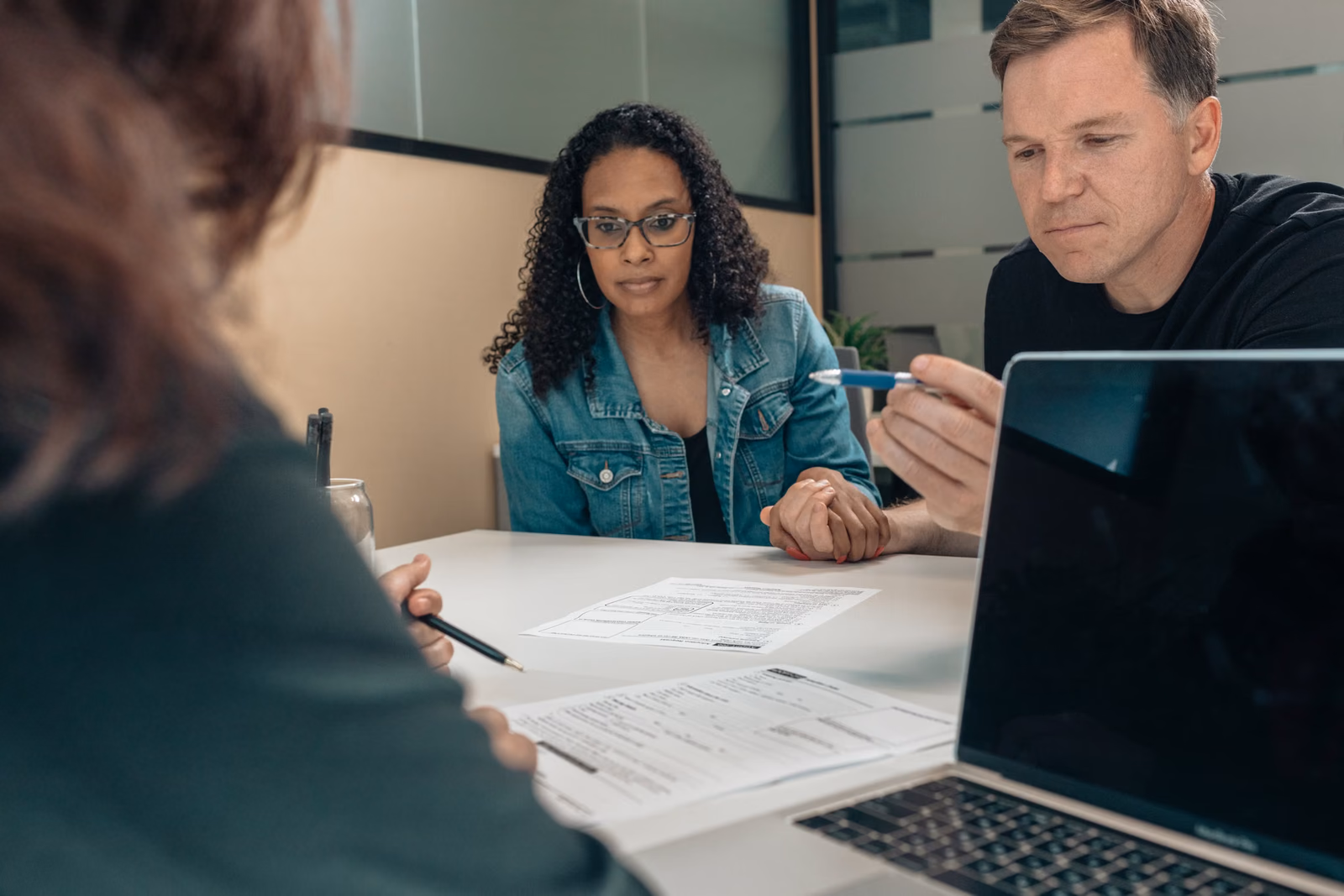 Adults discussing documents together across a desk
