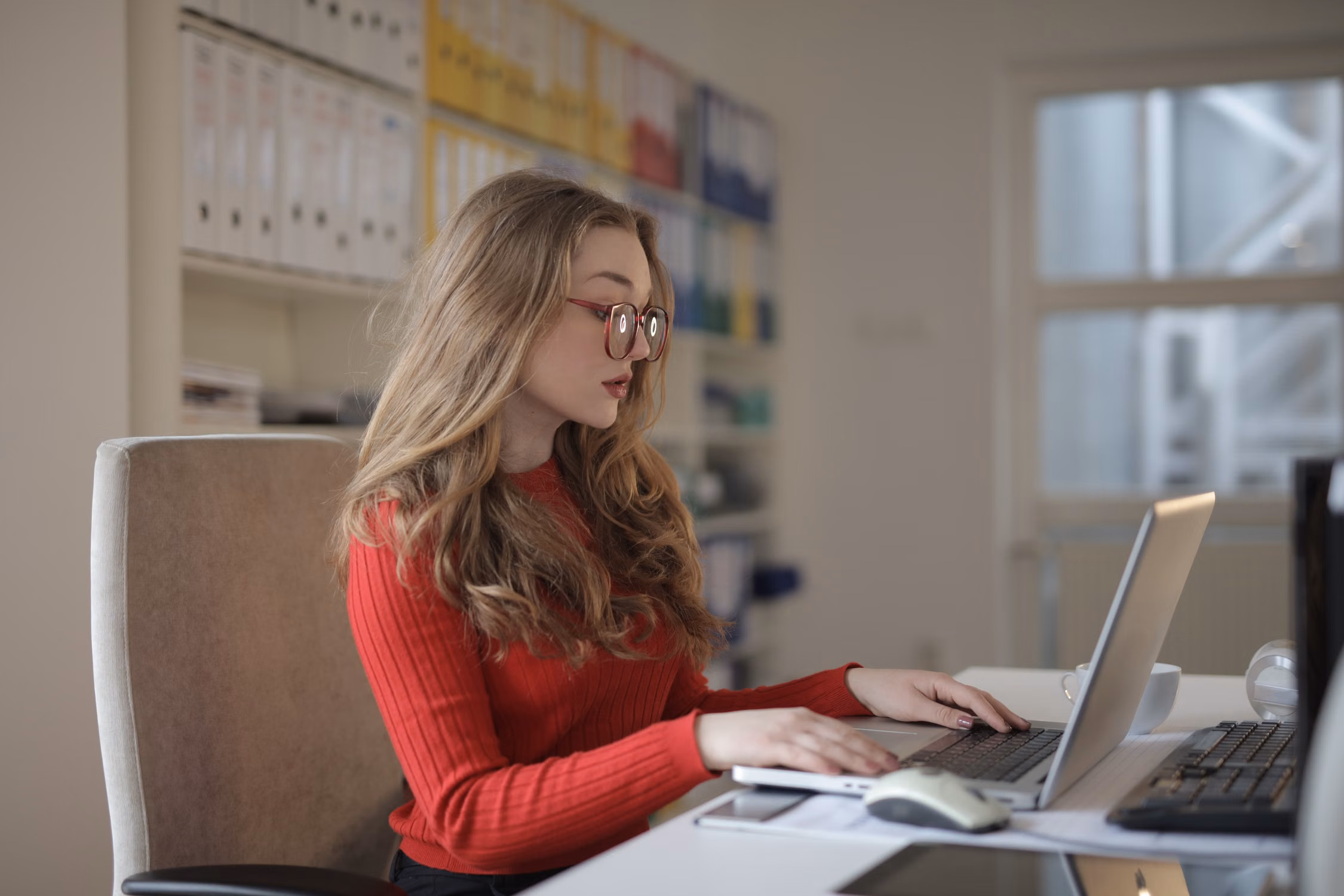 An independent professional working at a laptop in a bright office